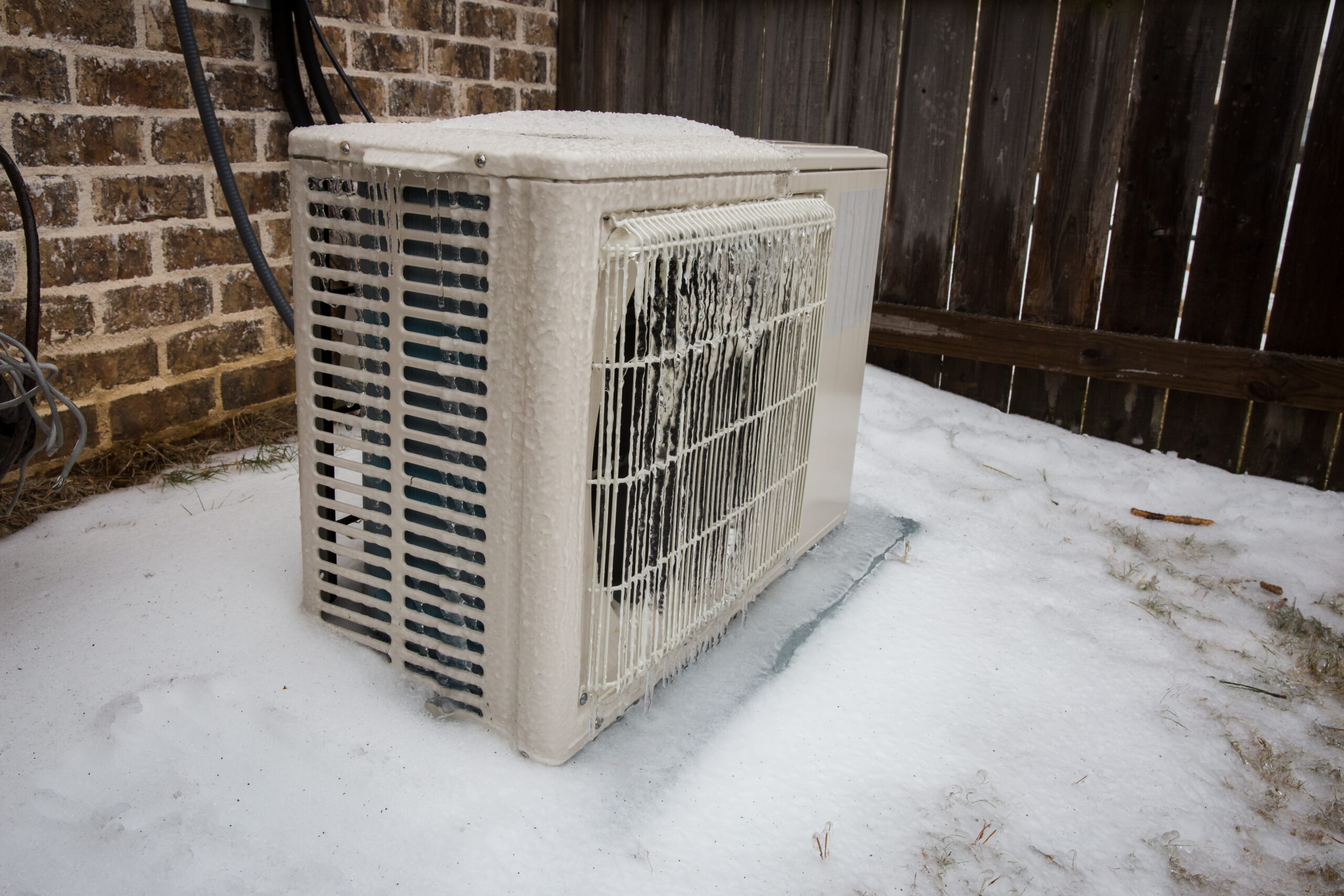 air conditioning outdoor unit covered in ice from winter storm